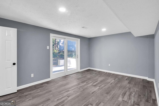 empty room featuring hardwood / wood-style flooring and a textured ceiling