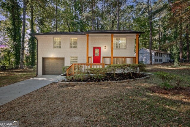 raised ranch featuring covered porch and a garage