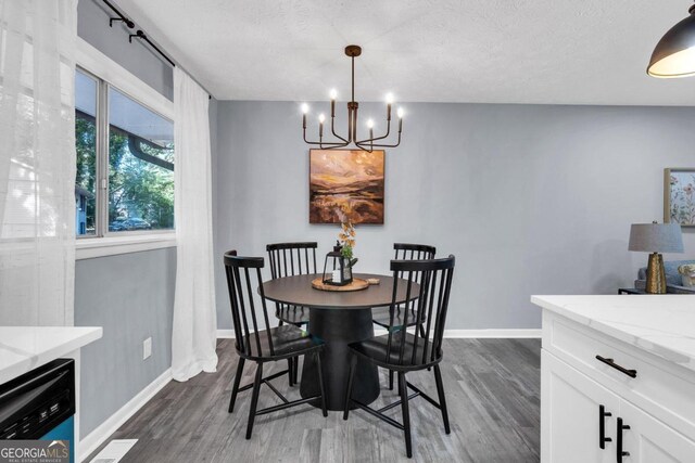 dining room with a notable chandelier, a textured ceiling, and dark hardwood / wood-style flooring