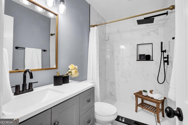 bathroom featuring toilet, walk in shower, and vanity