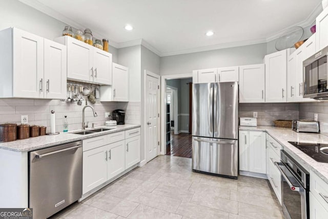 kitchen with crown molding, white cabinets, stainless steel appliances, and sink