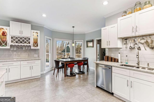 kitchen featuring crown molding, white cabinetry, stainless steel dishwasher, and hanging light fixtures