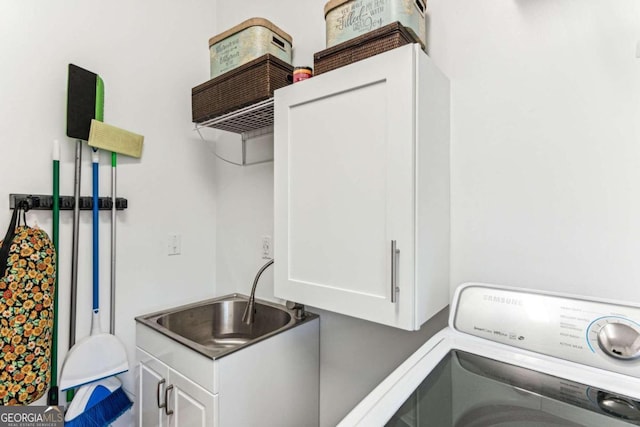 laundry area featuring sink, cabinets, and washer / clothes dryer