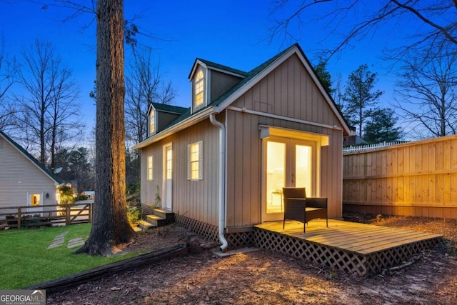 rear view of house with a wooden deck and a yard