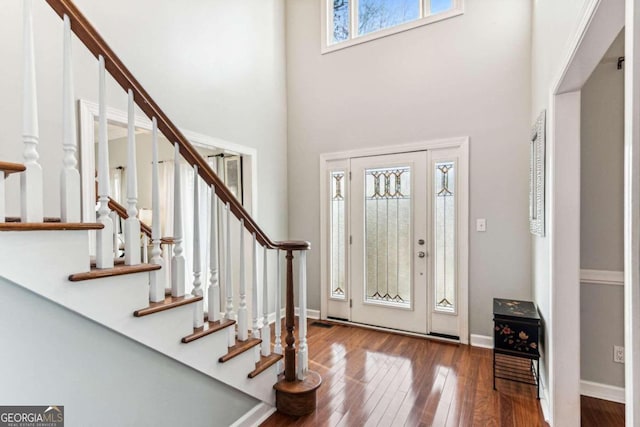 entryway with hardwood / wood-style floors and a high ceiling