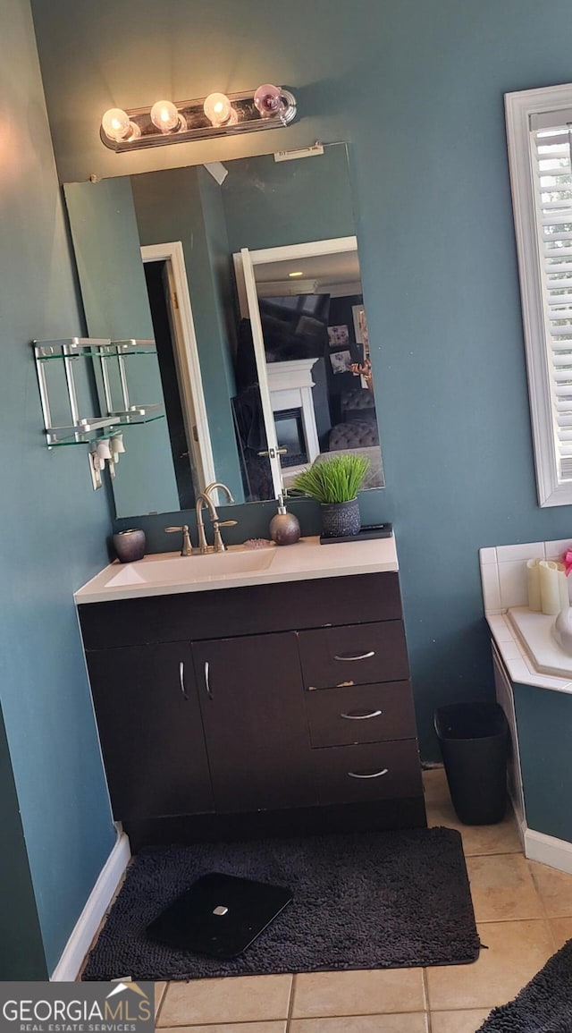 bathroom with tile patterned floors, a fireplace, and vanity