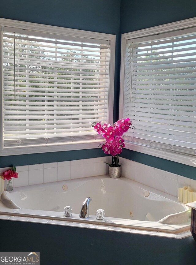 bathroom with a healthy amount of sunlight and tiled tub