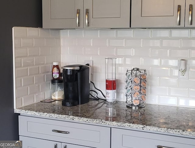 kitchen with decorative backsplash, gray cabinets, and light stone counters