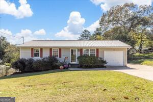 single story home featuring a front lawn and a garage