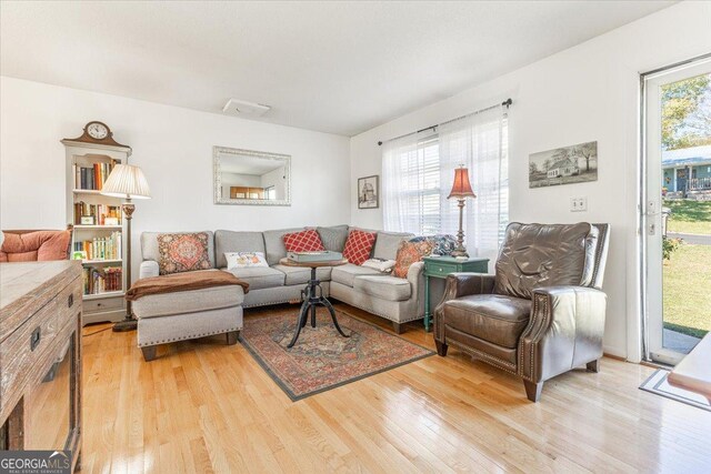 living room with light hardwood / wood-style flooring and a healthy amount of sunlight