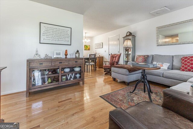 living room with hardwood / wood-style floors and a notable chandelier