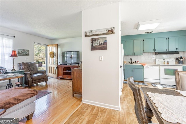 kitchen featuring ventilation hood, sink, decorative backsplash, white appliances, and light hardwood / wood-style flooring