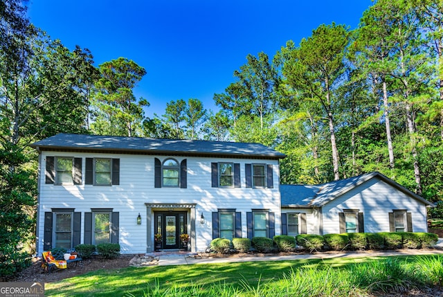 colonial home with french doors and a front yard