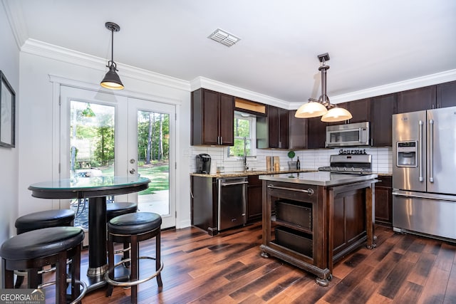 kitchen with pendant lighting, dark brown cabinets, dark wood-type flooring, and stainless steel appliances