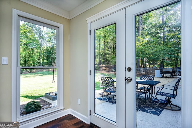 entryway with a healthy amount of sunlight, crown molding, and dark hardwood / wood-style floors