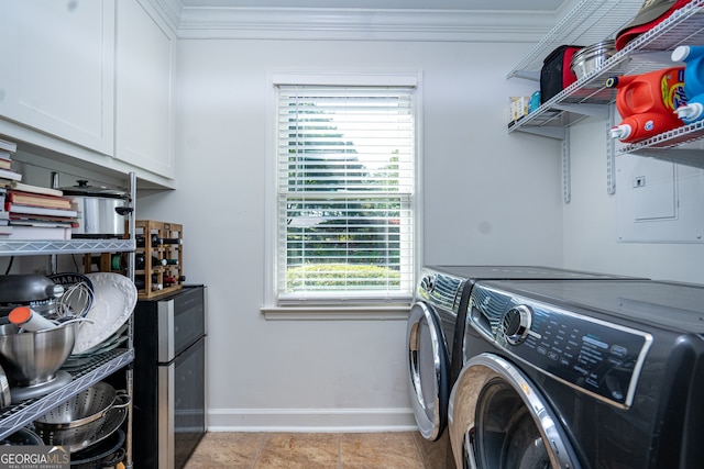 laundry room featuring crown molding, cabinets, separate washer and dryer, and light tile patterned floors