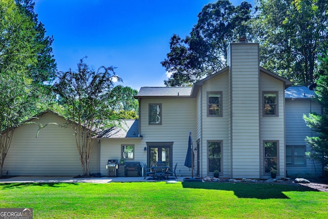 back of property featuring a patio area and a lawn