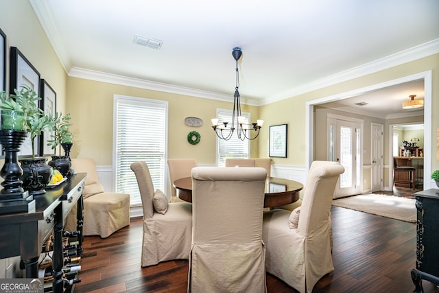 dining room with ornamental molding, dark wood-type flooring, and a chandelier