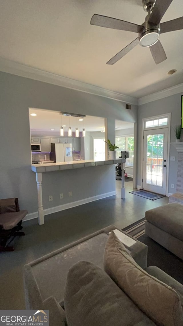 living room featuring ceiling fan and crown molding