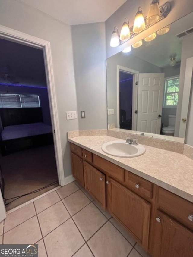 bathroom featuring tile patterned floors, vanity, and toilet