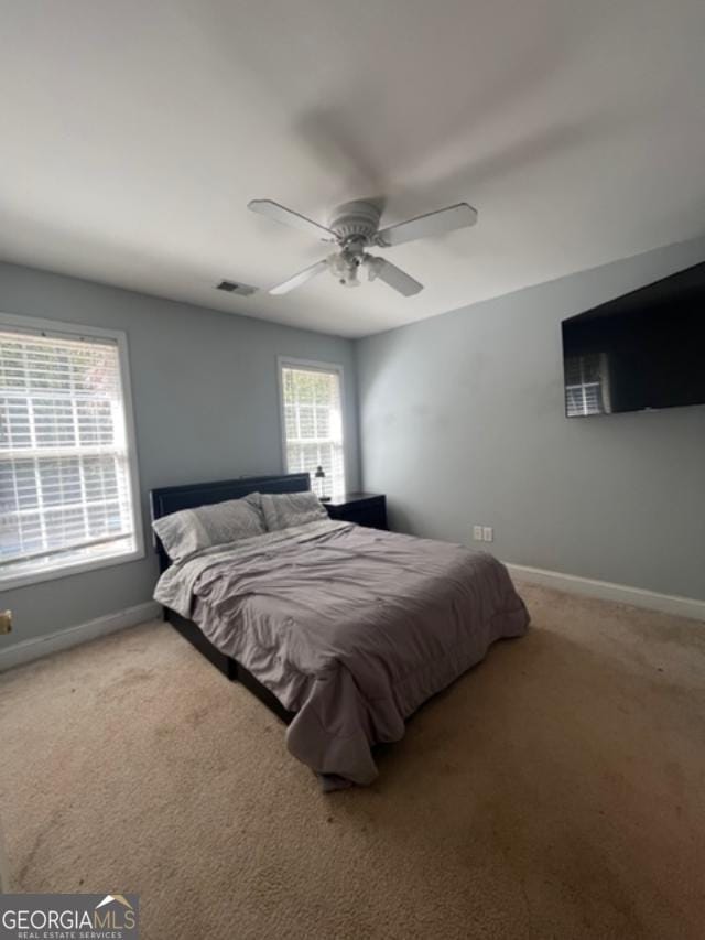 bedroom featuring carpet flooring, multiple windows, and ceiling fan