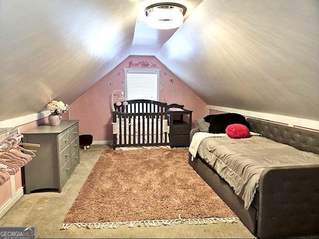 bedroom with light carpet and vaulted ceiling