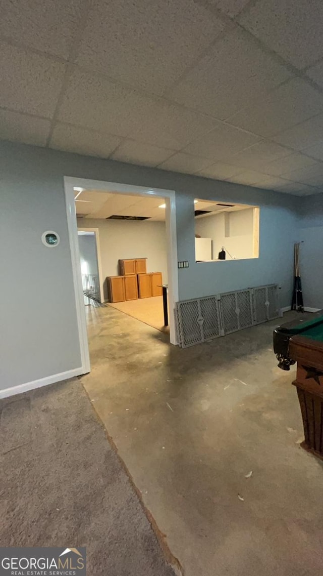 basement with a paneled ceiling and pool table