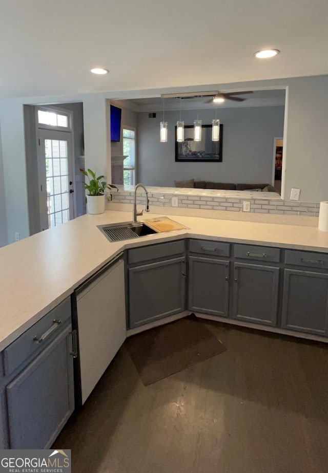 kitchen featuring dishwasher, decorative light fixtures, plenty of natural light, and sink