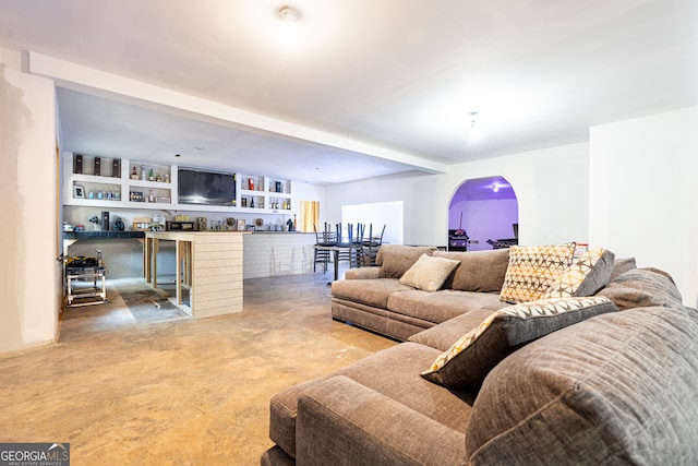 living room featuring built in features and concrete floors