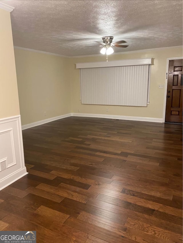 spare room with a textured ceiling, dark hardwood / wood-style floors, and ornamental molding