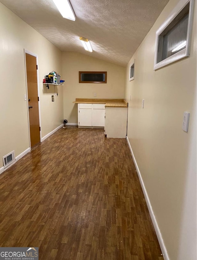 laundry area with dark hardwood / wood-style flooring and a textured ceiling