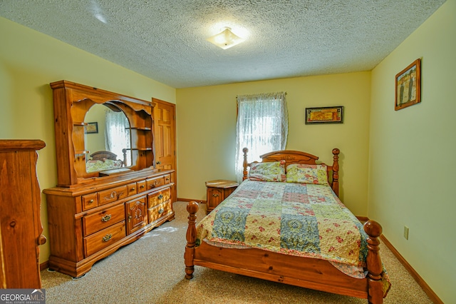 bedroom featuring light colored carpet and a textured ceiling