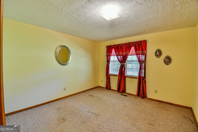 spare room featuring a textured ceiling and carpet flooring