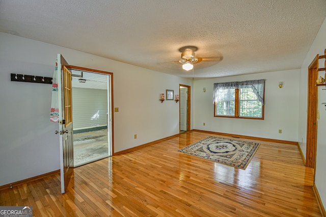 empty room featuring ceiling fan, a textured ceiling, and light hardwood / wood-style flooring