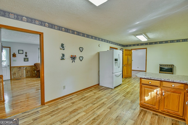 kitchen with white fridge with ice dispenser, a textured ceiling, light wood-type flooring, and heating unit