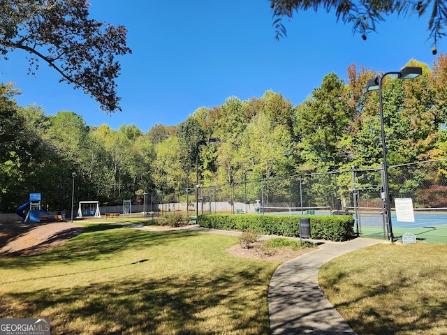 view of home's community with a yard and tennis court