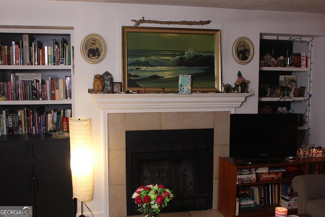 living room featuring a tiled fireplace