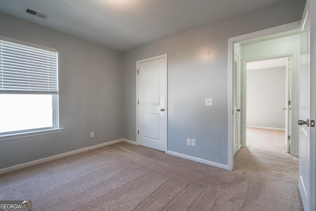 unfurnished bedroom with light colored carpet