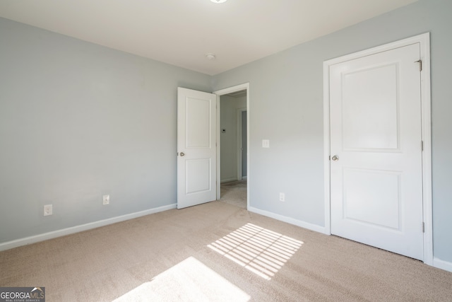 unfurnished bedroom featuring light carpet