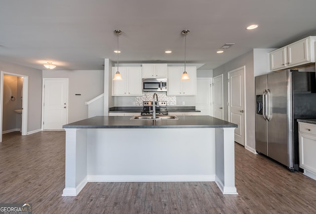 kitchen featuring stainless steel appliances, dark wood-type flooring, sink, pendant lighting, and white cabinetry