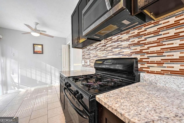 kitchen featuring light tile patterned flooring, ceiling fan, black gas range, decorative backsplash, and light stone countertops