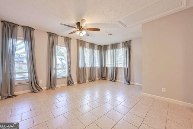 tiled empty room with ceiling fan and a textured ceiling