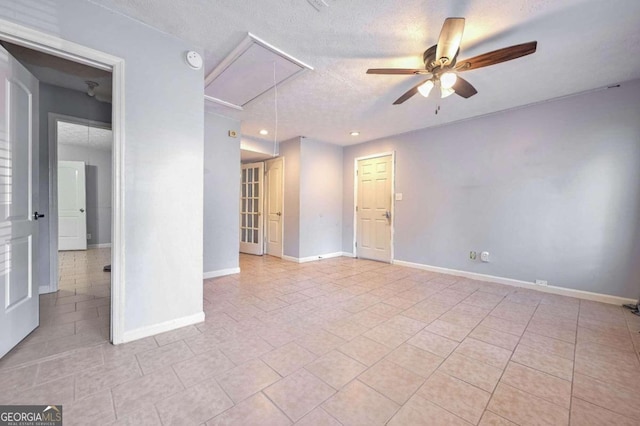 empty room with light tile patterned floors, a textured ceiling, and ceiling fan