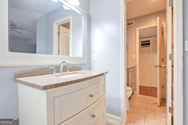 bathroom featuring tile patterned floors, vanity, and toilet