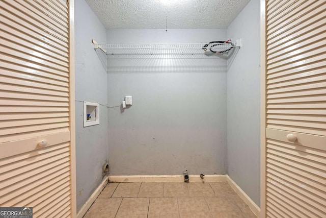 laundry room featuring light tile patterned flooring, hookup for a washing machine, and a textured ceiling