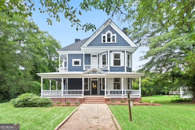 victorian-style house featuring covered porch and a front yard