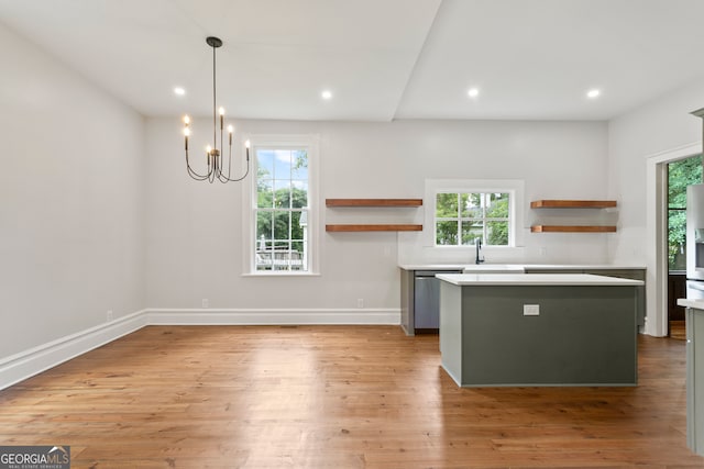 kitchen featuring plenty of natural light, decorative light fixtures, and light hardwood / wood-style floors