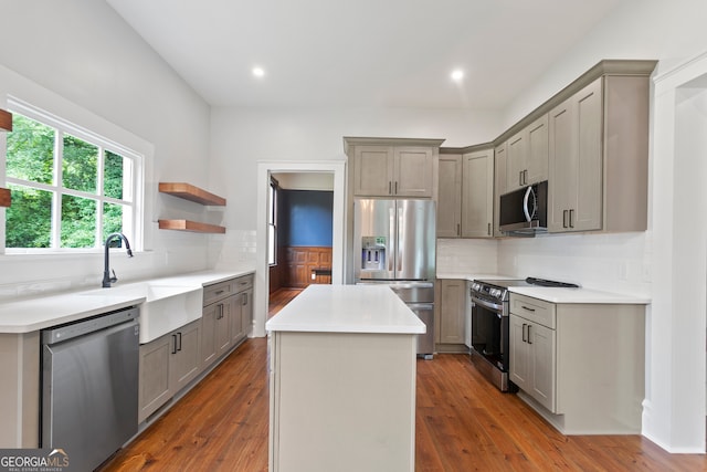 kitchen with wood-type flooring, a kitchen island, stainless steel appliances, and gray cabinetry