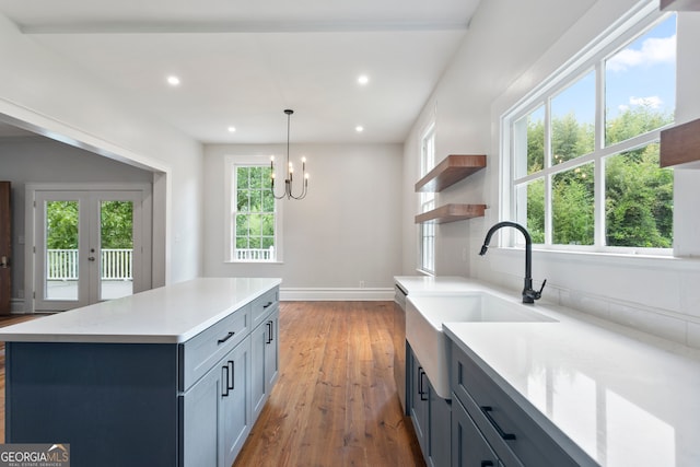 kitchen featuring gray cabinets, plenty of natural light, dark wood-type flooring, and decorative light fixtures