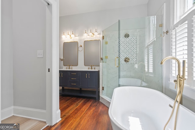 bathroom with vanity, hardwood / wood-style floors, and plus walk in shower